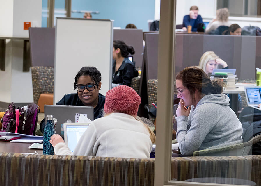 Students study together and work on their computers.