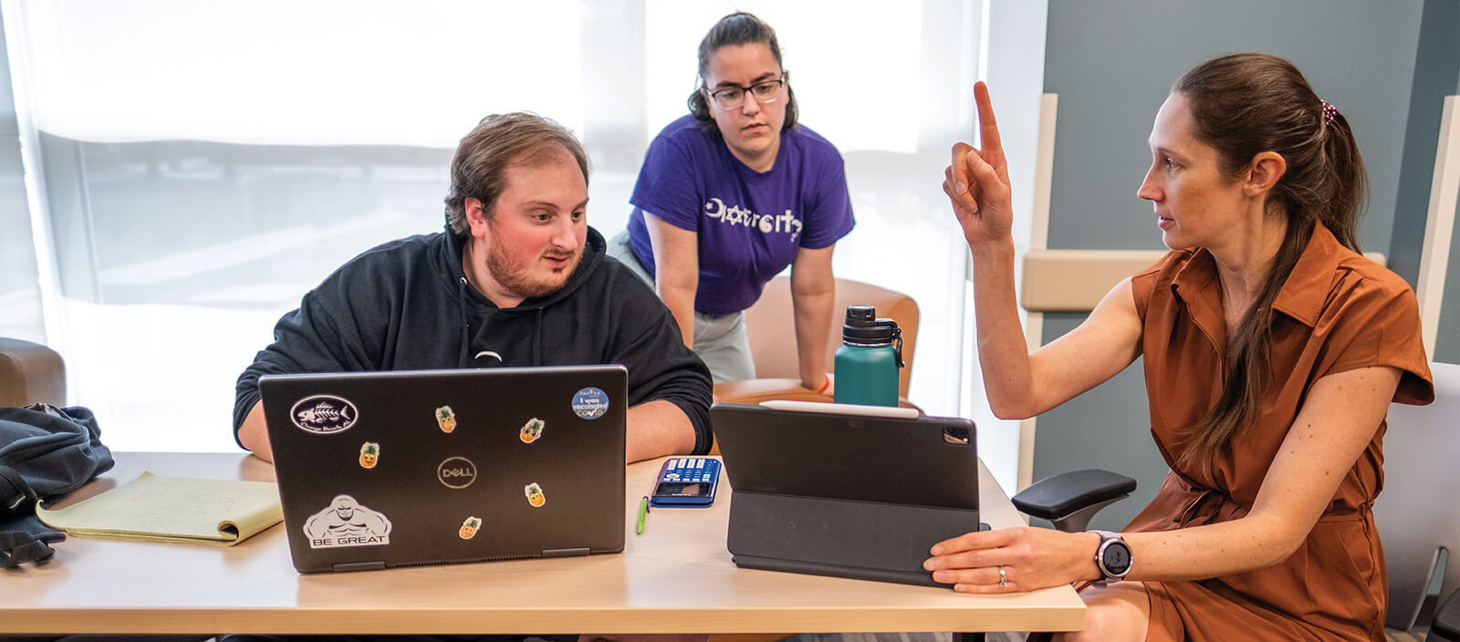 Professor Lindsey R. Bosko-Dunbar instructing two students at a desk.