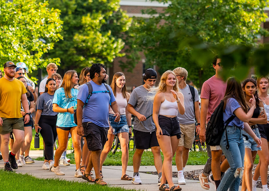 A group of students walk across campus