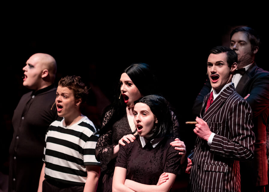 Students sing on stage during a performance